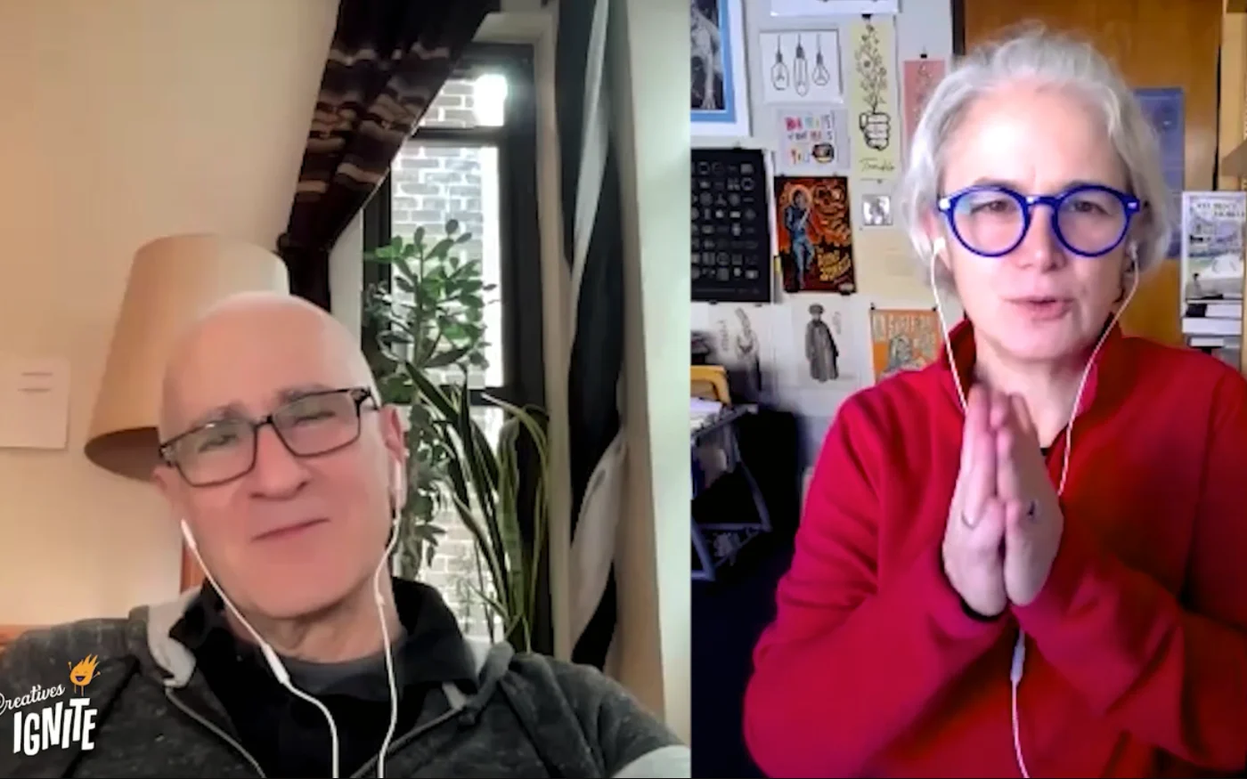 Screenshot — a split-screen video call: on the left, a person in rectangular glasses and earbuds beside a window and a tall plant; on the right, a person in round blue glasses and a red top, hands pressed together, in front of a wall of pinned prints